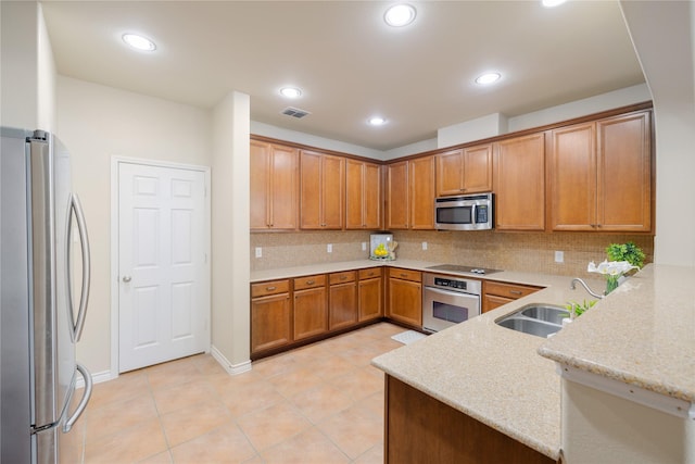 kitchen with kitchen peninsula, decorative backsplash, sink, light stone countertops, and stainless steel appliances