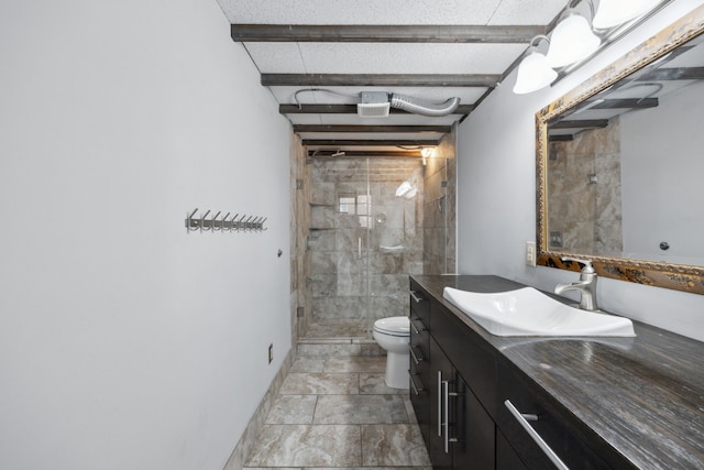 bathroom featuring toilet, beam ceiling, tiled shower, and vanity