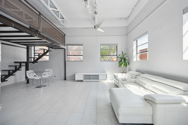 living room with ceiling fan and a high ceiling