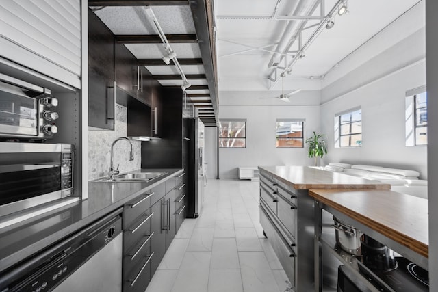 kitchen with ceiling fan, appliances with stainless steel finishes, decorative backsplash, and sink