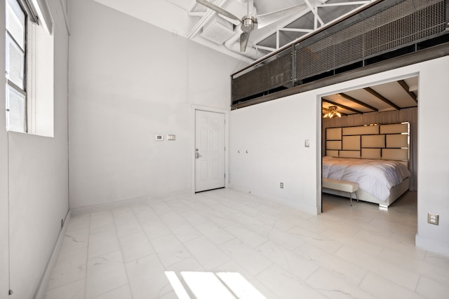 interior space with ceiling fan and a high ceiling