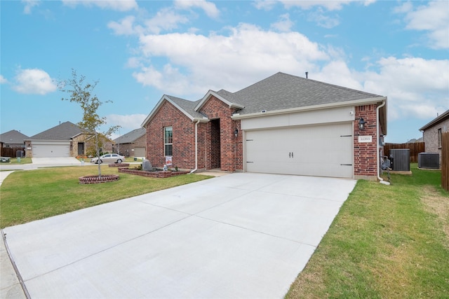 view of front of home with a garage, cooling unit, and a front lawn