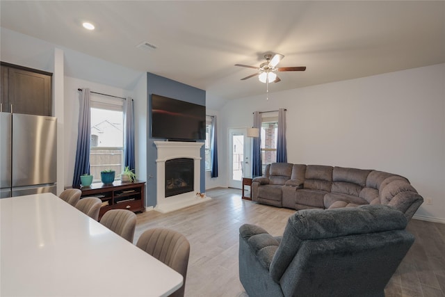 living room with ceiling fan and light hardwood / wood-style flooring