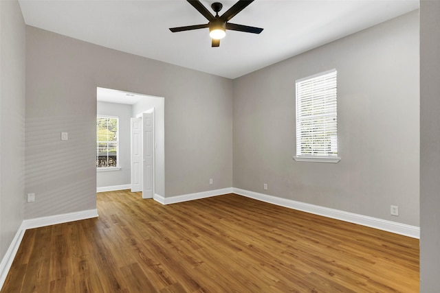 empty room featuring ceiling fan, plenty of natural light, and hardwood / wood-style floors