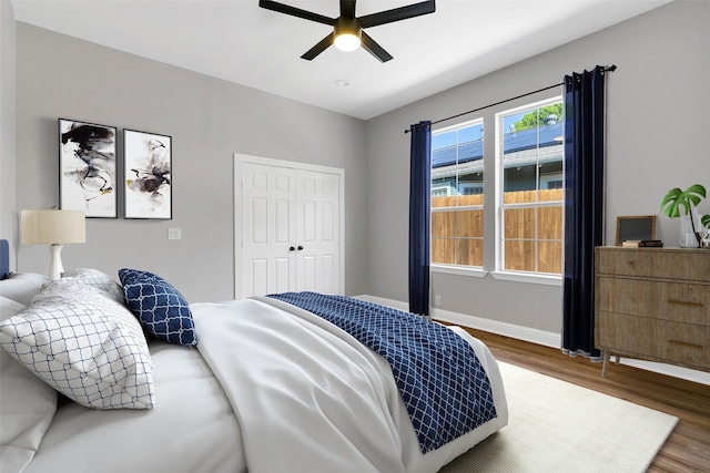 bedroom featuring ceiling fan, dark hardwood / wood-style flooring, and a closet