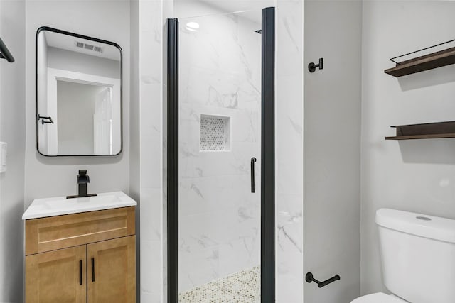 bathroom featuring a shower with door, toilet, and vanity