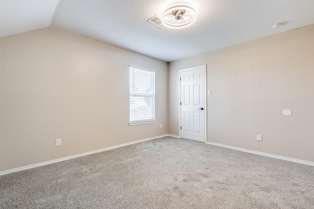 empty room with lofted ceiling and carpet flooring