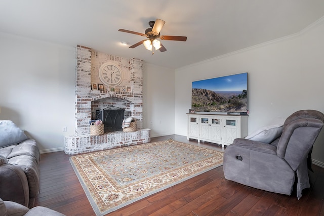 living room with a fireplace, ceiling fan, dark hardwood / wood-style flooring, and ornamental molding