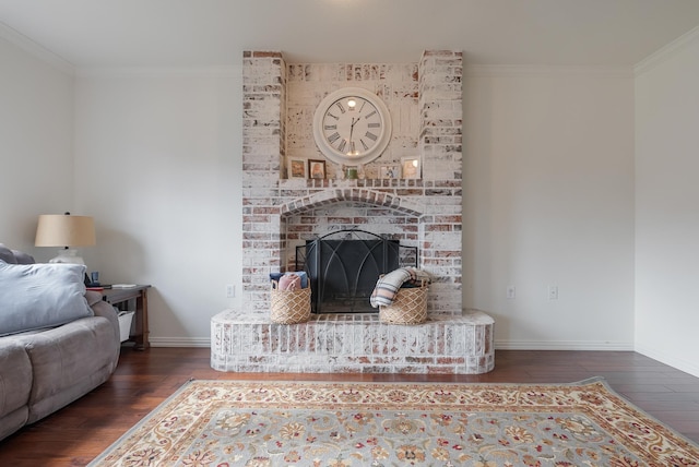 living room with dark wood-type flooring, ornamental molding, and a brick fireplace