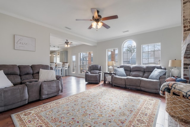 living room featuring dark wood-type flooring, ornamental molding, a healthy amount of sunlight, and ceiling fan