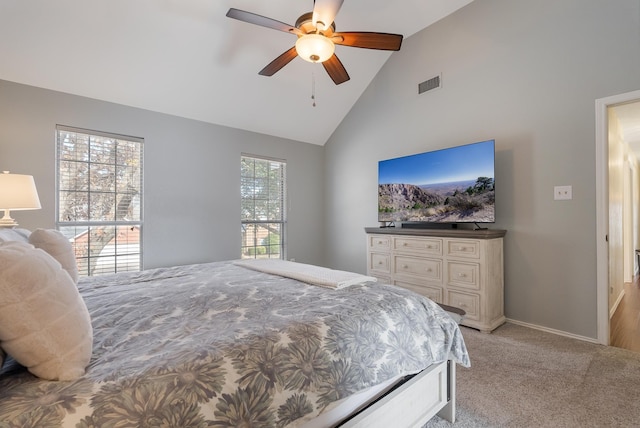 bedroom with ceiling fan, light colored carpet, high vaulted ceiling, and multiple windows