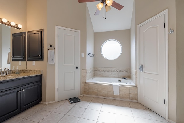 bathroom featuring a relaxing tiled tub, tile patterned floors, vanity, and vaulted ceiling