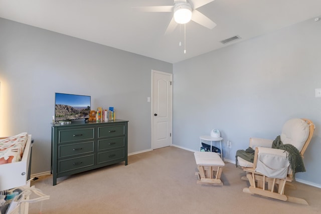 sitting room with ceiling fan and light colored carpet