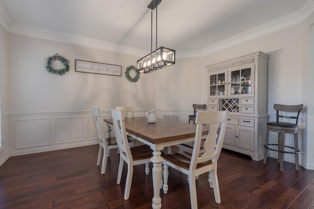 dining area with dark hardwood / wood-style floors, crown molding, and a notable chandelier