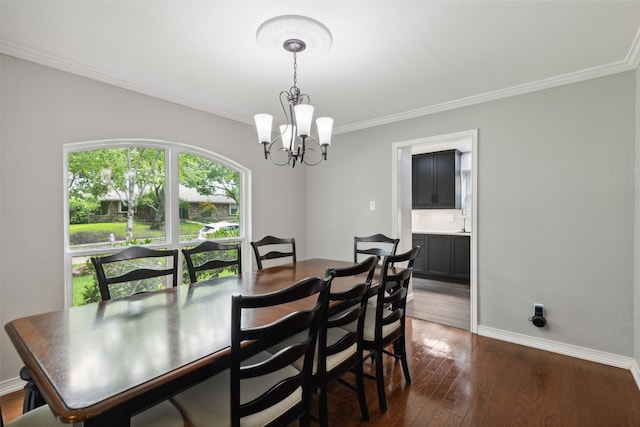 dining room with dark hardwood / wood-style floors, crown molding, and a chandelier