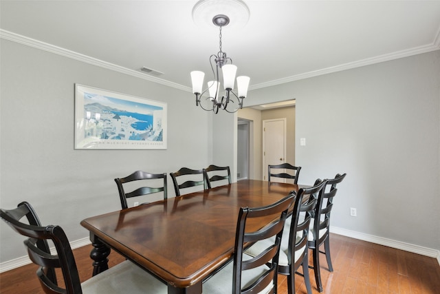 dining space with a chandelier, crown molding, and hardwood / wood-style floors