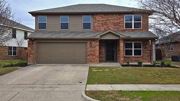 view of front property featuring a garage, central AC unit, and a front yard