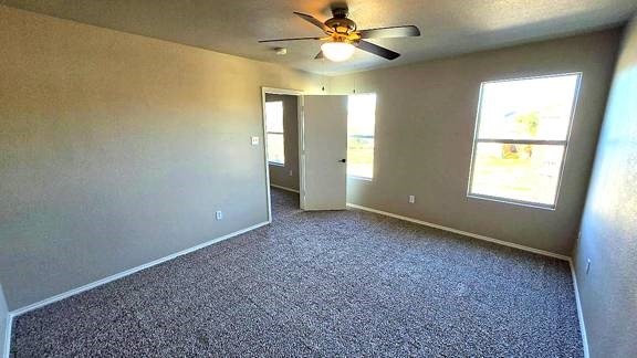 carpeted empty room featuring ceiling fan