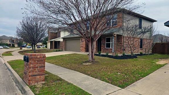 view of property featuring a garage and a front yard