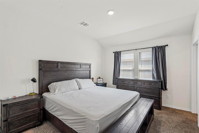 bedroom with dark colored carpet and lofted ceiling