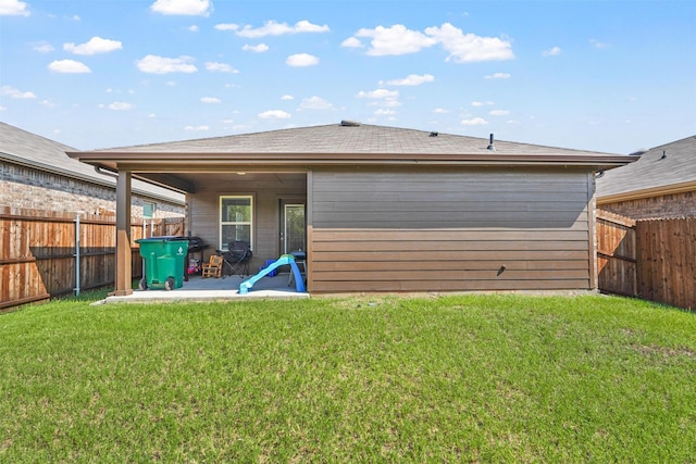 rear view of property featuring a patio area and a yard