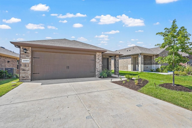 prairie-style house featuring a front yard, a garage, and central AC