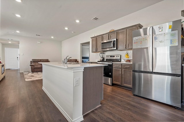 kitchen featuring sink, appliances with stainless steel finishes, a center island with sink, and dark hardwood / wood-style flooring