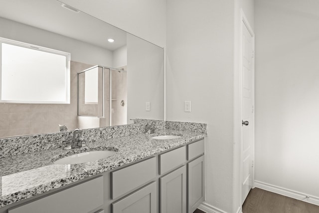 bathroom featuring a shower with door, wood-type flooring, and vanity