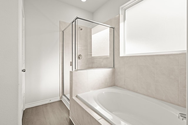 bathroom with wood-type flooring and independent shower and bath