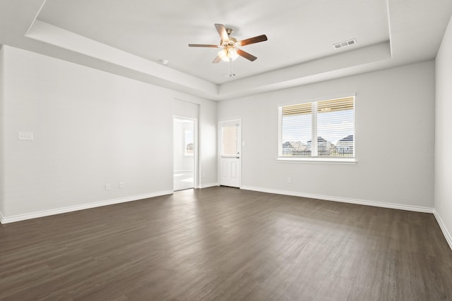 5041 Wellborn Rd, Fort Worth, TX 76036 - empty room featuring a tray ceiling, ceiling fan, dark wood-type flooring, and baseboards