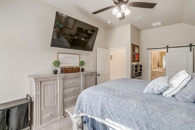 carpeted bedroom with ceiling fan, connected bathroom, a barn door, and vaulted ceiling