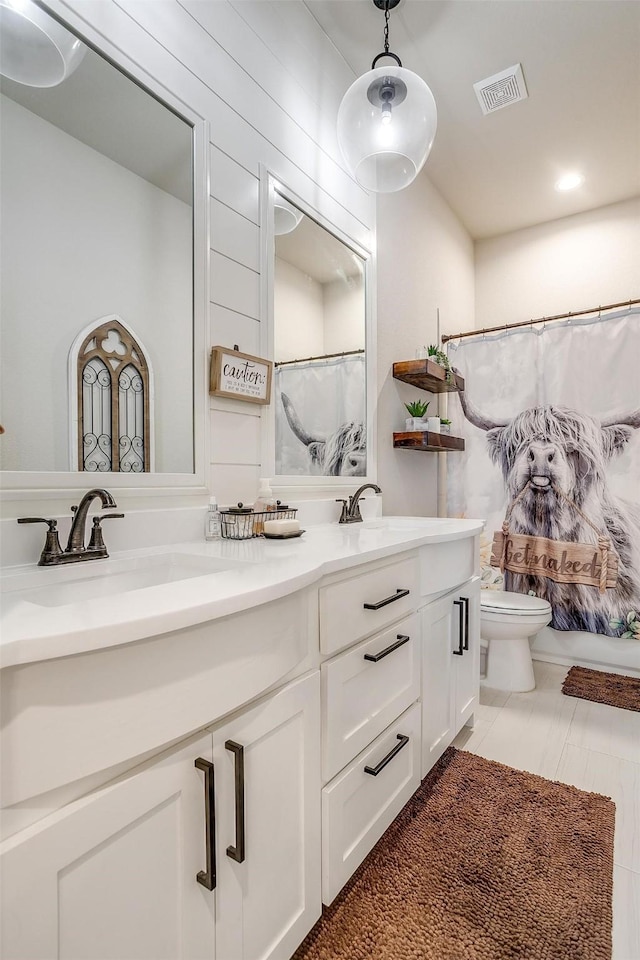 bathroom with walk in shower, vanity, toilet, tile patterned floors, and wooden walls