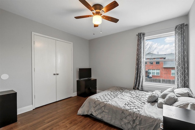 bedroom with dark wood-type flooring, a closet, and ceiling fan