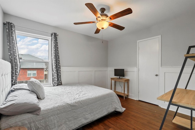 bedroom with ceiling fan, multiple windows, and dark hardwood / wood-style floors