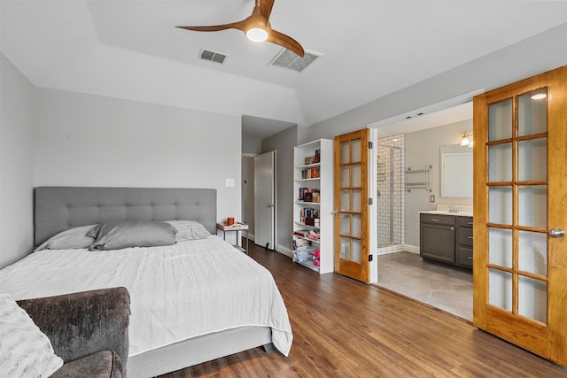 bedroom with ceiling fan, french doors, dark hardwood / wood-style floors, connected bathroom, and lofted ceiling