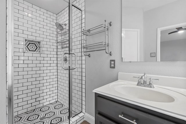 bathroom featuring a shower with shower door and vanity