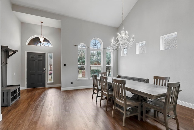 dining space with high vaulted ceiling, dark hardwood / wood-style flooring, and a notable chandelier