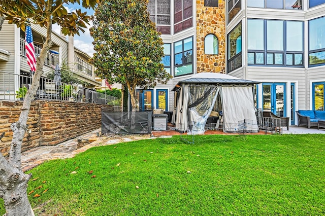 back of property with a lawn and a gazebo