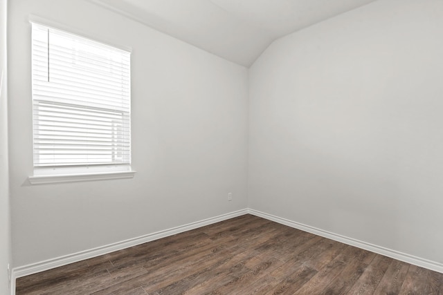 spare room with lofted ceiling and dark hardwood / wood-style flooring