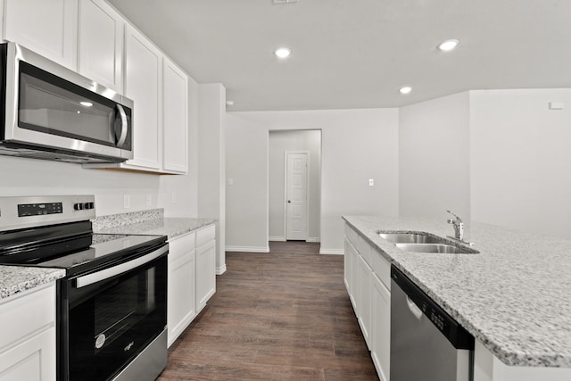 kitchen with white cabinetry, stainless steel appliances, sink, dark hardwood / wood-style floors, and light stone counters