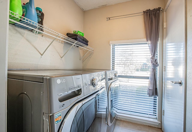 laundry room with tile patterned flooring, separate washer and dryer, and a textured ceiling