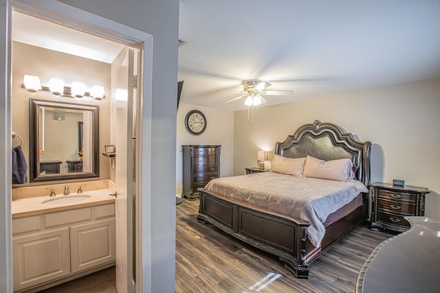 bedroom featuring ceiling fan, sink, dark hardwood / wood-style floors, and ensuite bath