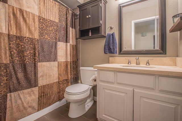 bathroom with toilet, vanity, and tile patterned floors