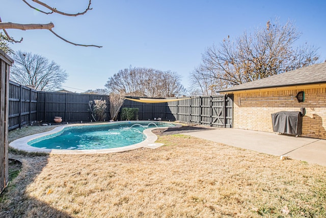 view of swimming pool featuring a yard, grilling area, and a patio