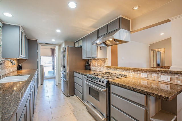 kitchen featuring sink, appliances with stainless steel finishes, dark stone counters, and exhaust hood