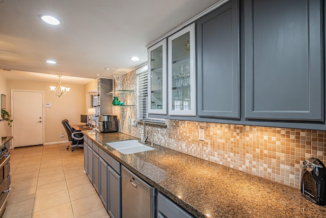 kitchen featuring dark stone countertops, stainless steel dishwasher, sink, light tile patterned flooring, and hanging light fixtures