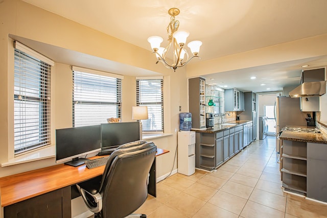 tiled home office with sink, washer / dryer, and a chandelier