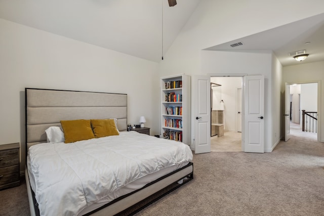 bedroom featuring ceiling fan, light colored carpet, ensuite bathroom, and high vaulted ceiling