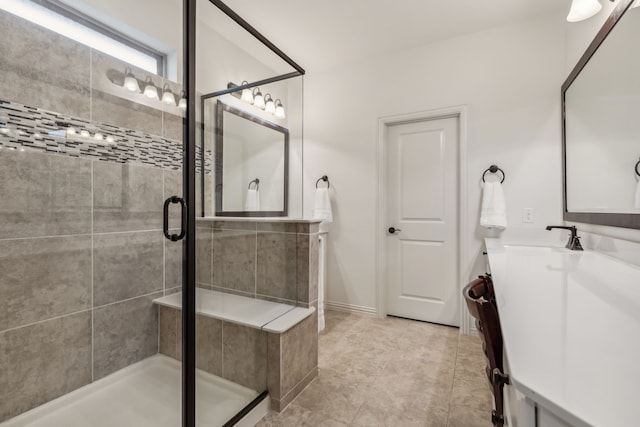 bathroom featuring a shower with shower door and vanity