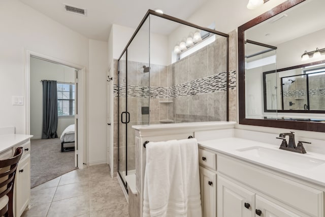 bathroom with an enclosed shower, vanity, and tile patterned flooring